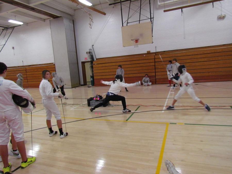 Teammates fence against each other for practice before the meet starts. 