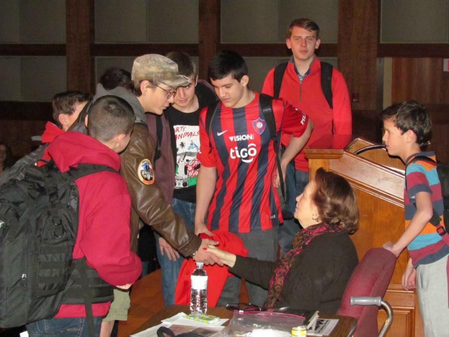 Students shaking hands with Marsha Kreuzman.