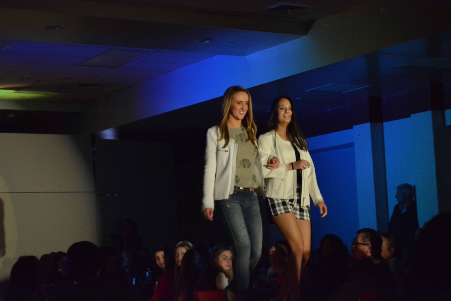 Molly Kauffman and Sophia Das link arms to walk down the runway. 