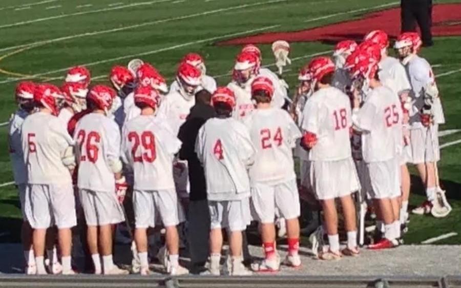 Lacrosse boys get together to go over plays. 