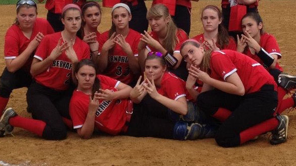 The Varsity Softball team poses for a picture after a game.