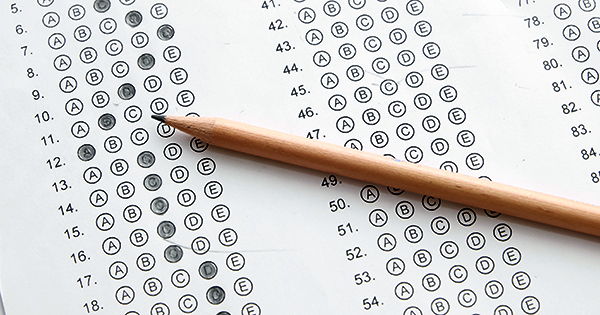 Standardized test form with answers bubbled in and a pencil, focus on answer sheet
