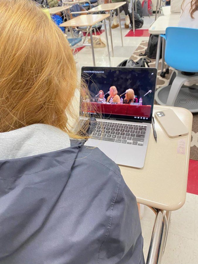 Student watches Dr. Dempseys resignation speech at Board of Education meeting