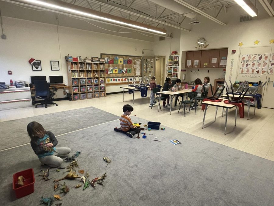 Preschool 2 classroom during afternoon playtime; playing with toys and sitting at a coloring station.