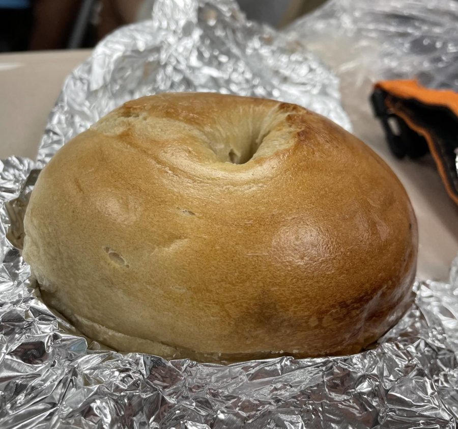 A bagel, a very common breakfast food, wrapped in tinfoil. 