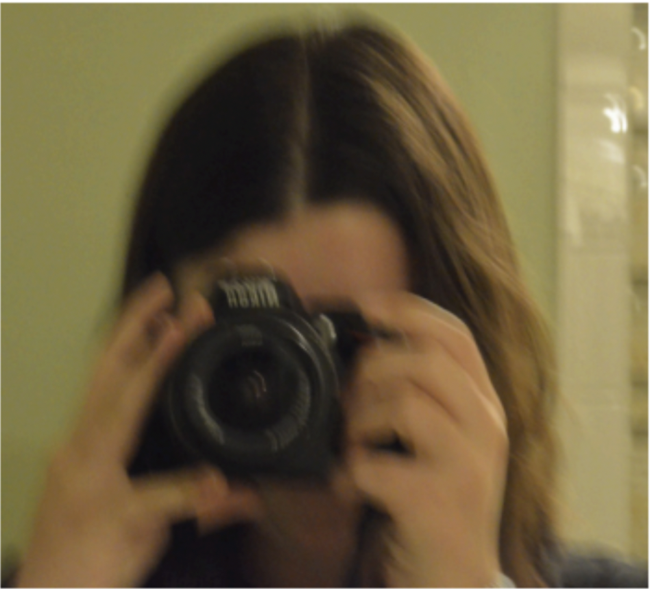 Claire Taylor, filmmaker and photographer, poses with her camera in hand