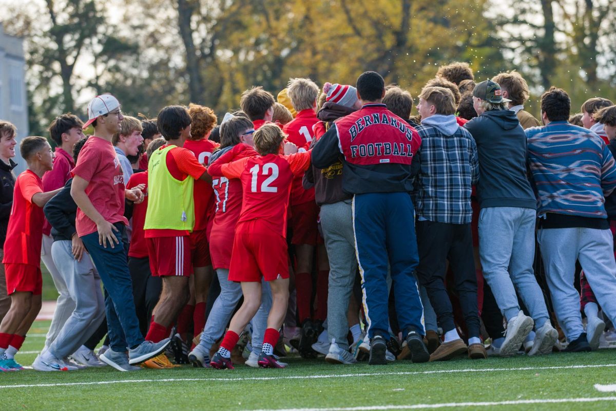 The boys soccer team and student section celebrate after the sectional championship game. 