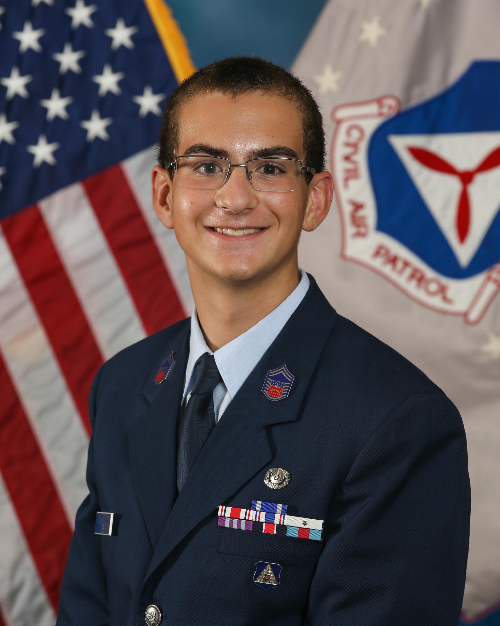 Aidan Kinsey, Civil Air Patrol Cadet, smiles in a suit, featuring many medals of honor