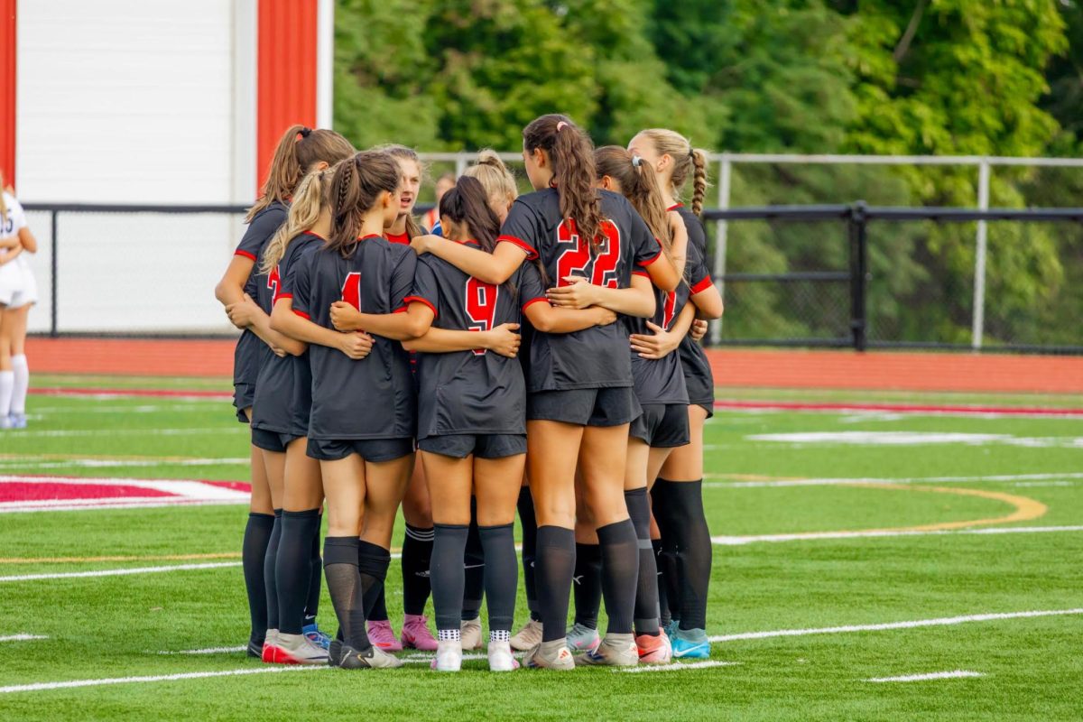 The Bernards Girls Soccer team huddles before their home opener.
