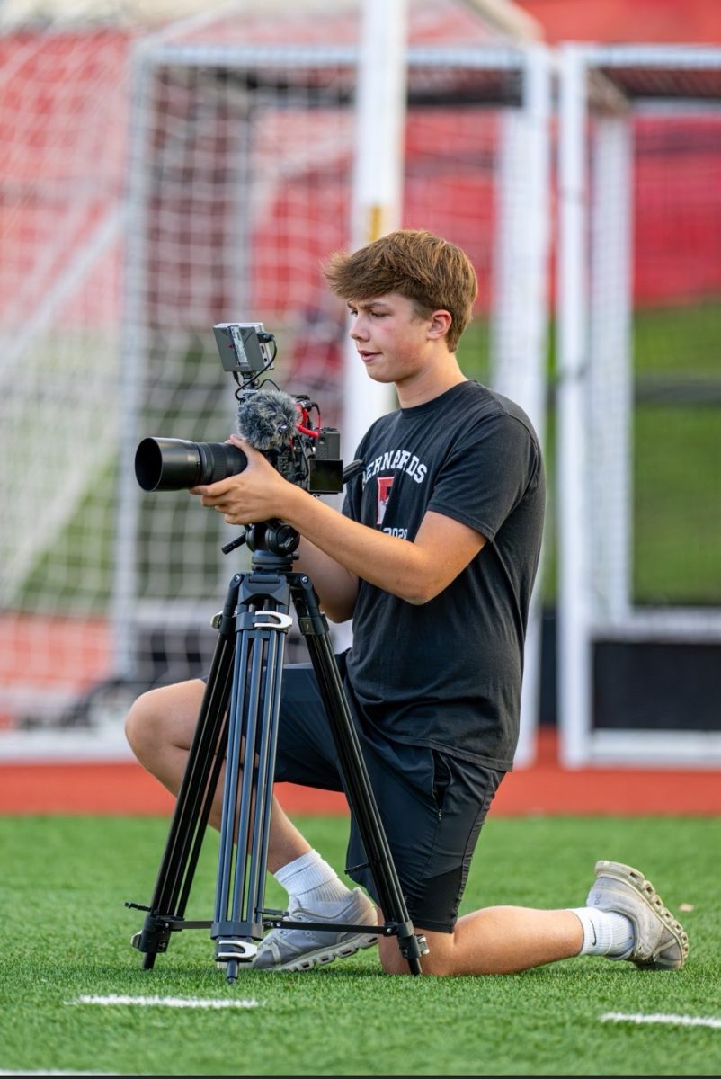Macklin Dunnder prepares for a game by setting up his camera on a tripod