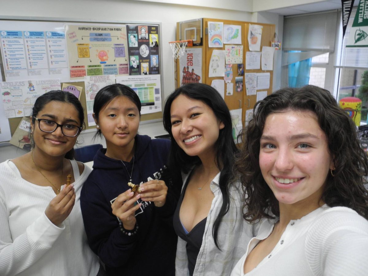 Ella Patel '26, Riley Omlor '26, Elizabeth Chen '26, and Ria Lewis '26 participate in chess club with their peers during unit lunch.