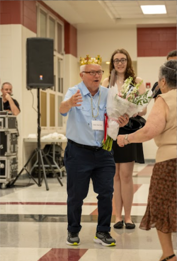 Intergenerational prom King accepts his award after being named king of prom. 